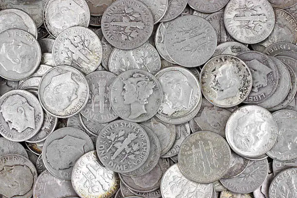 Old silver dimes on a white background.