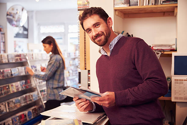 istock Man working behind the counter at a record shop, portrait 478693564