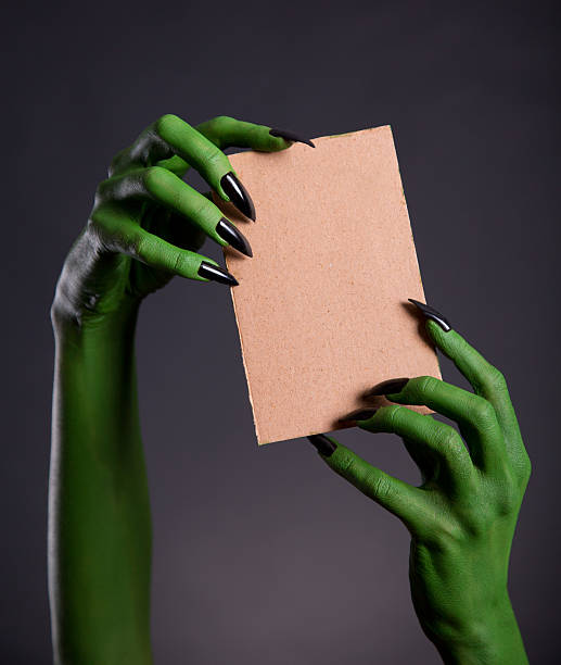 istock Green monster hands holding empty piece of cardboard 478693722