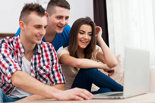 istock Young friends looking on laptop at home 478695281