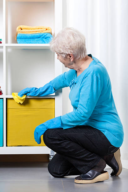 istock Elderly woman during dusting furniture 478698979