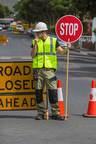 istock traffic controller talking to radio and holding stop sign 478703639