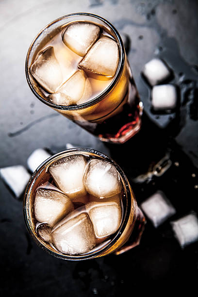 istock cola with ice on a wooden background. soft drinks 478704698