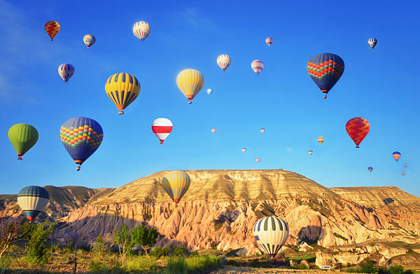 ballons air chaud coloré contre ciel bleu - hot air balloon flying heat people photos et images de collection