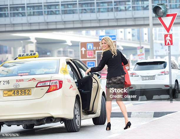 Woman Entering Dubai Cab Stock Photo - Download Image Now - 2015, Adult, Blond Hair