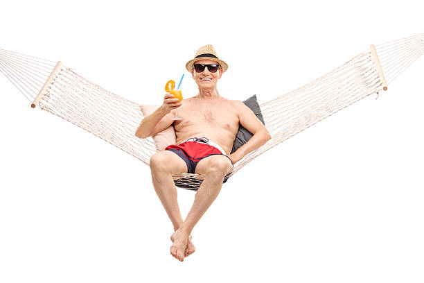 istock Senior lying in hammock and drinking a cocktail 478707910