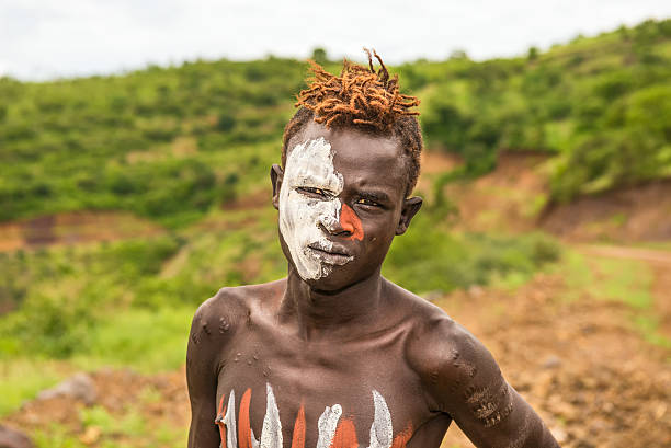 Omo Valley, Ethiopia - May 7, 2015 : Young man from the African tribe Mursi with traditionally painted face in Mago National Park, Ethiopia.