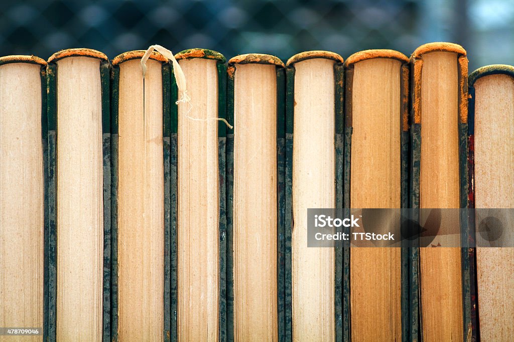 Old books in a row Old books leaning against each other in a row Book Spine Stock Photo