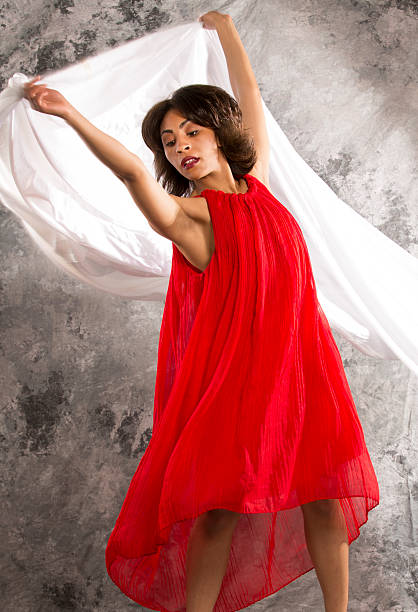 istock Attractive young female dancer with white fabric and grey backgr 478714680