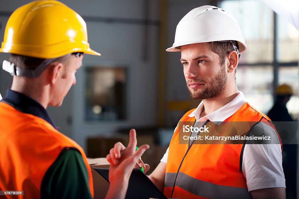 Warehouse workers consulting Two warehouse workers discussing about new project Warehouse Worker Stock Photo