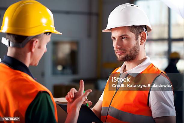Warehouse Workers Consulting Stock Photo - Download Image Now - Warehouse Worker, Discussion, Talking