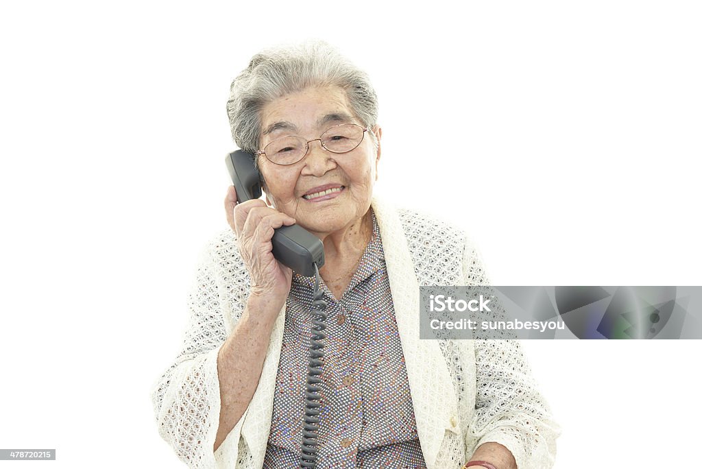 Happy old woman talking on the phone Happy old woman talking on the phone isolated on white background Using Phone Stock Photo