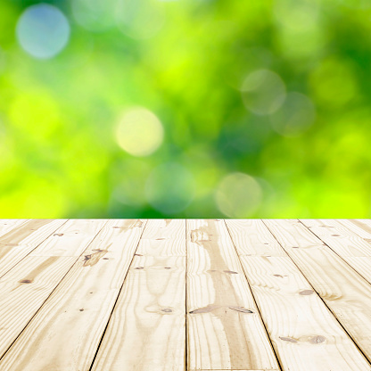 Wood table top on green blurry backgrounds.