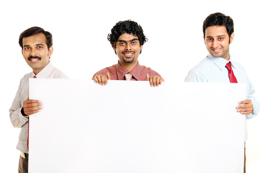 three Indian businesspeople holding the white board isolated on white.