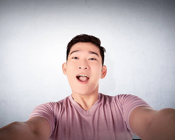 istock Handsome young man holding camera and making selfie 478729326