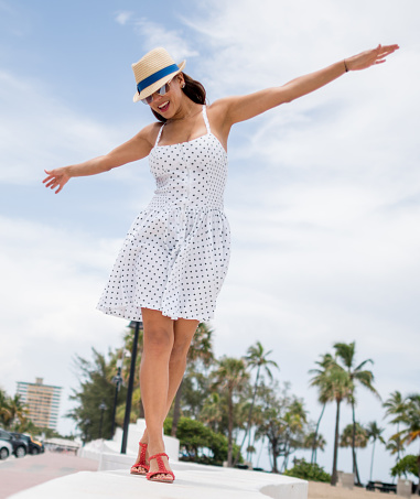 Summer woman enjoying a day at the beach in Miami and balancing