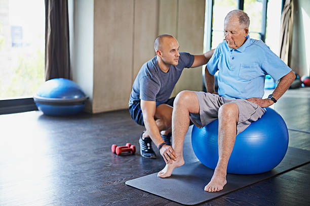 erhaltung seiner muskeln durch physiotherapie - senior adult exercising aging process instructor stock-fotos und bilder