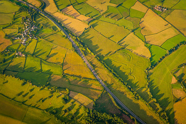 istock Highway curving through green patchwork fields farms villages aerial view 478732106