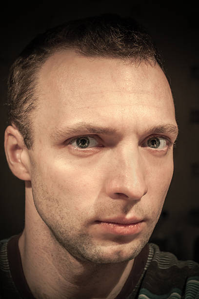 istock Young serious Caucasian man closeup portrait on dark background 478732663