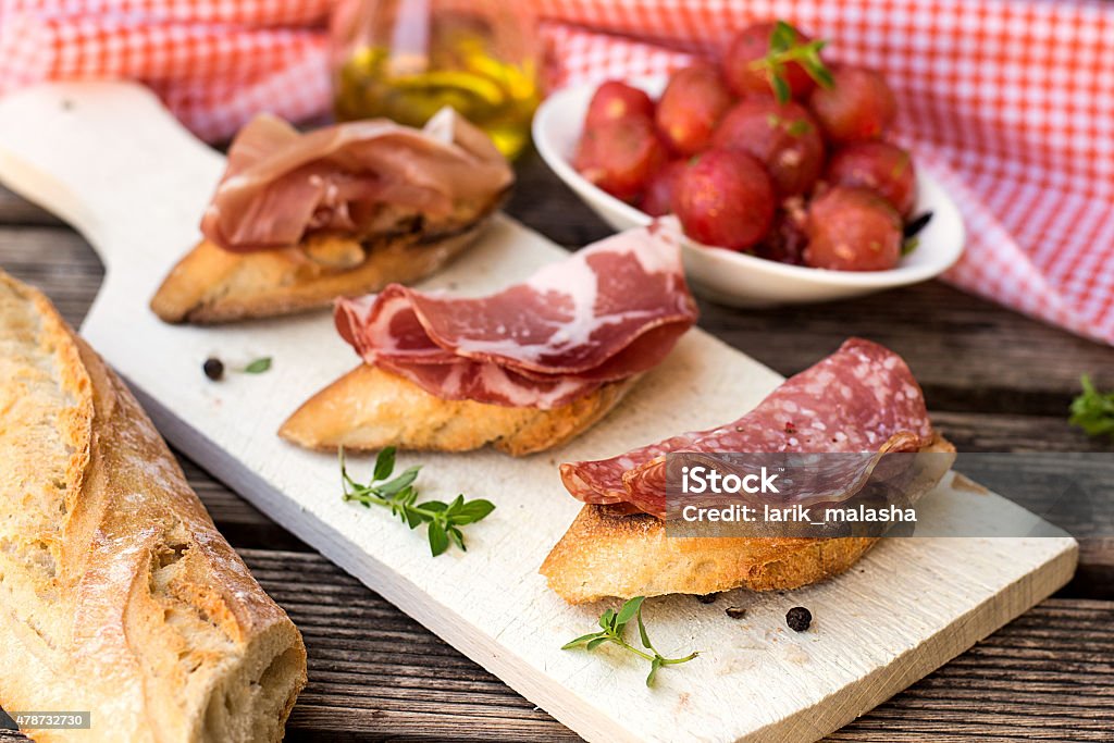 Italiana bruschettas con antipasto de jamón y salami prosciutto, copa - Foto de stock de 2015 libre de derechos