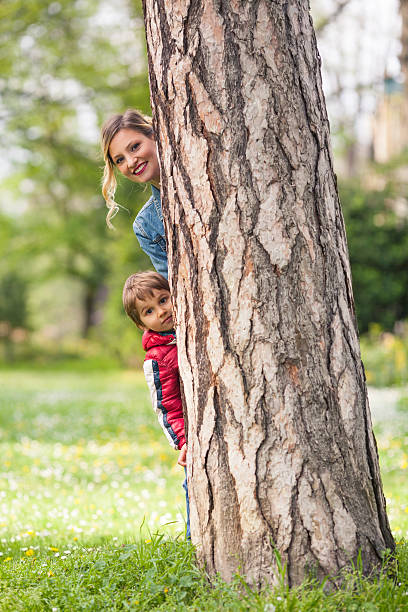 istock Mother and Son Peeking Out From Behind the Tree 478739810