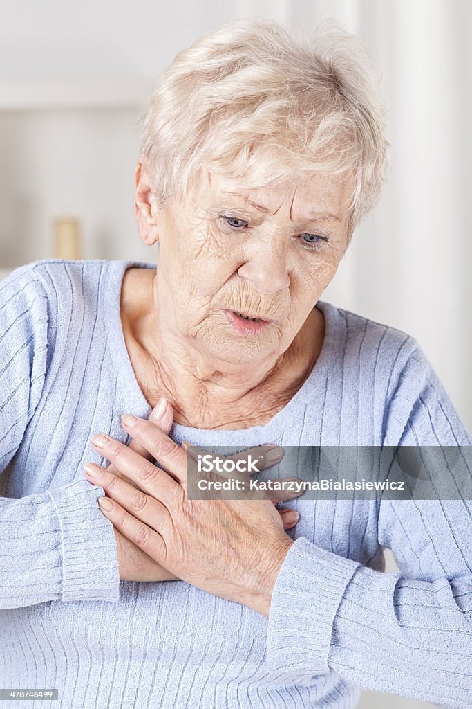 Elderly lady with chest pain Elderly lady with strong chest pain, vertical Women Stock Photo
