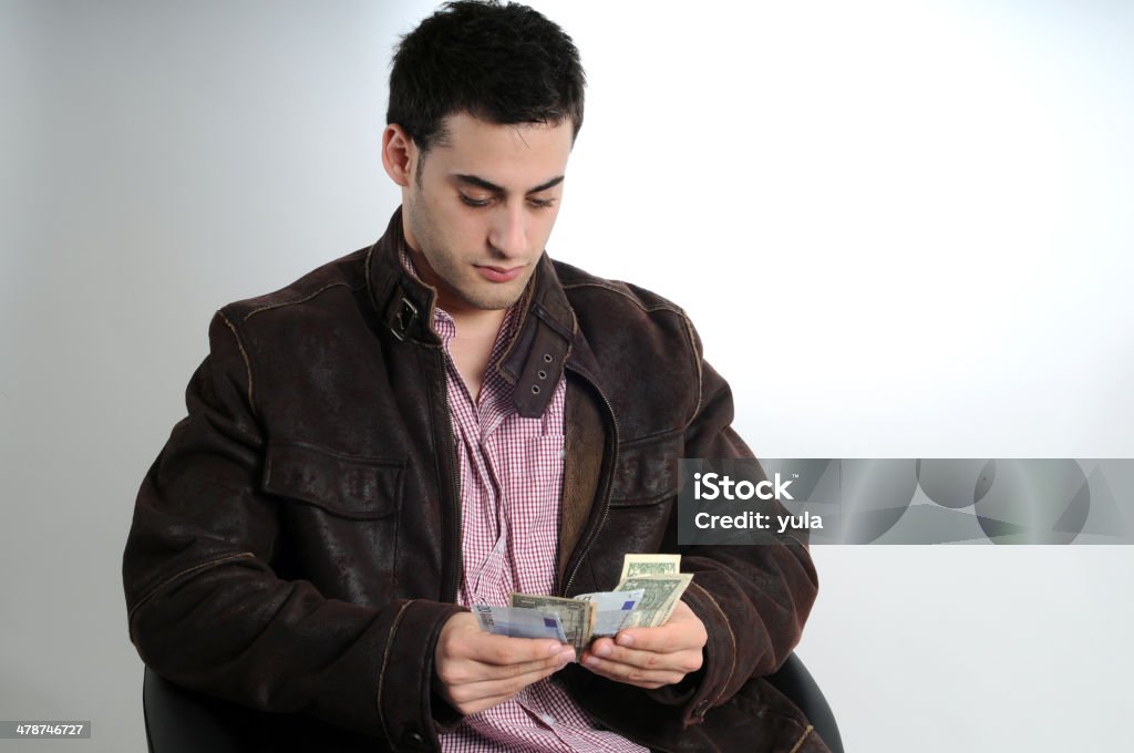 Young man counting money Young man counting money bills. Looking down Adult Stock Photo