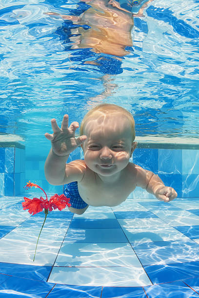 istock Child swimming underwater for a red flower in the pool 478751404