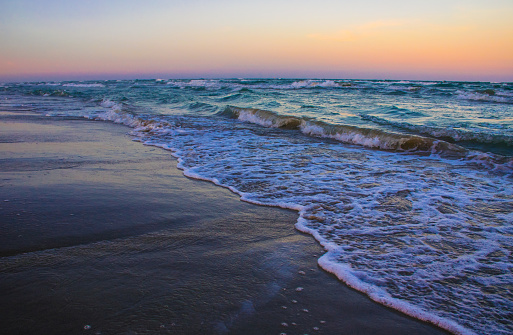 Texas Waves Crashing on Padre Island Sunset Beachs. Miles and Miles of Coast line run along the Texas Coast. Colors along the horizon show all the colors of the rainbow displayed at sunset. Padre Island , Mustang Beach. Reflections walking on the beach. 