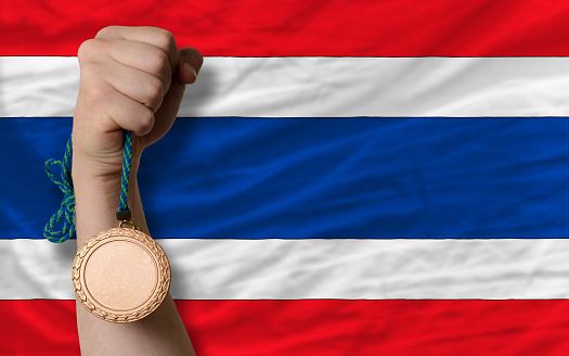 Holding bronze medal for sport and national flag of thailand