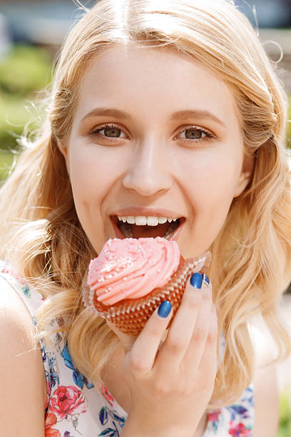 istock Close-up of woman with cupcake 478755218