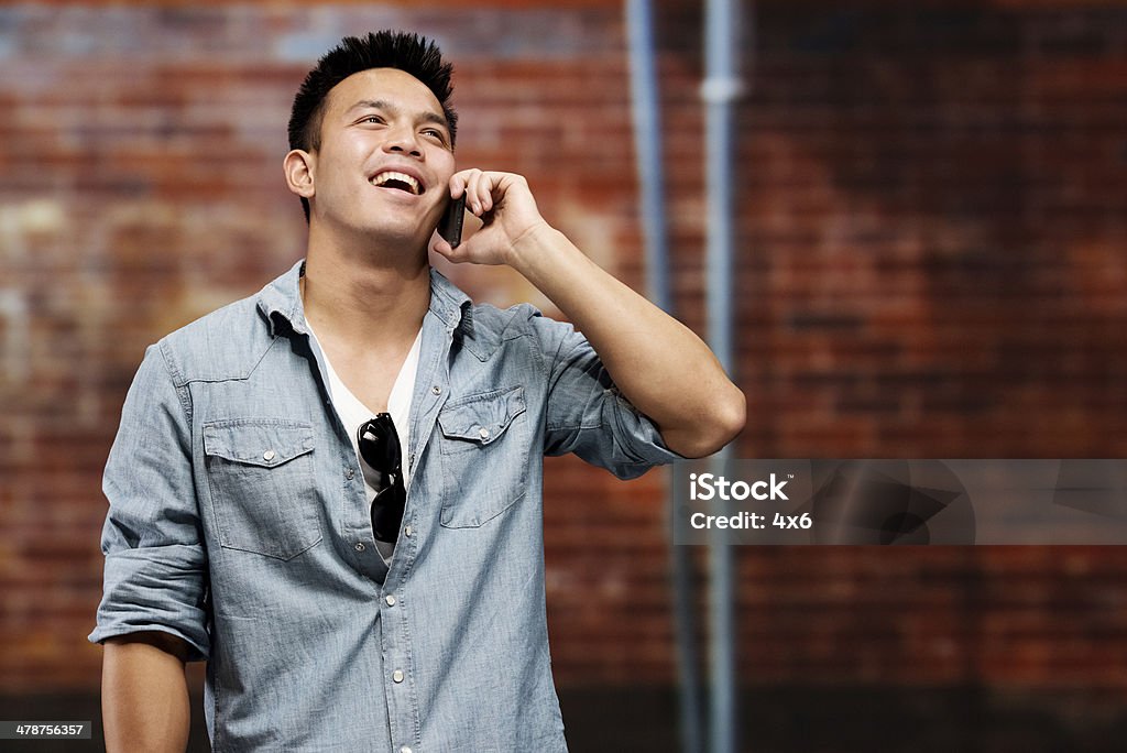 Casual man talking on mobile in front of wall Casual man talking on mobile in front of wallhttp://www.twodozendesign.info/i/1.png 20-29 Years Stock Photo