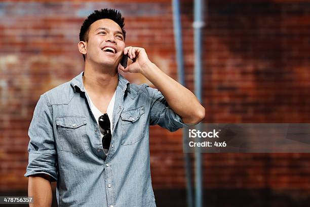 Casual Man Talking On Mobile In Front Of Wall Stock Photo - Download Image Now - 20-29 Years, Adult, Adults Only