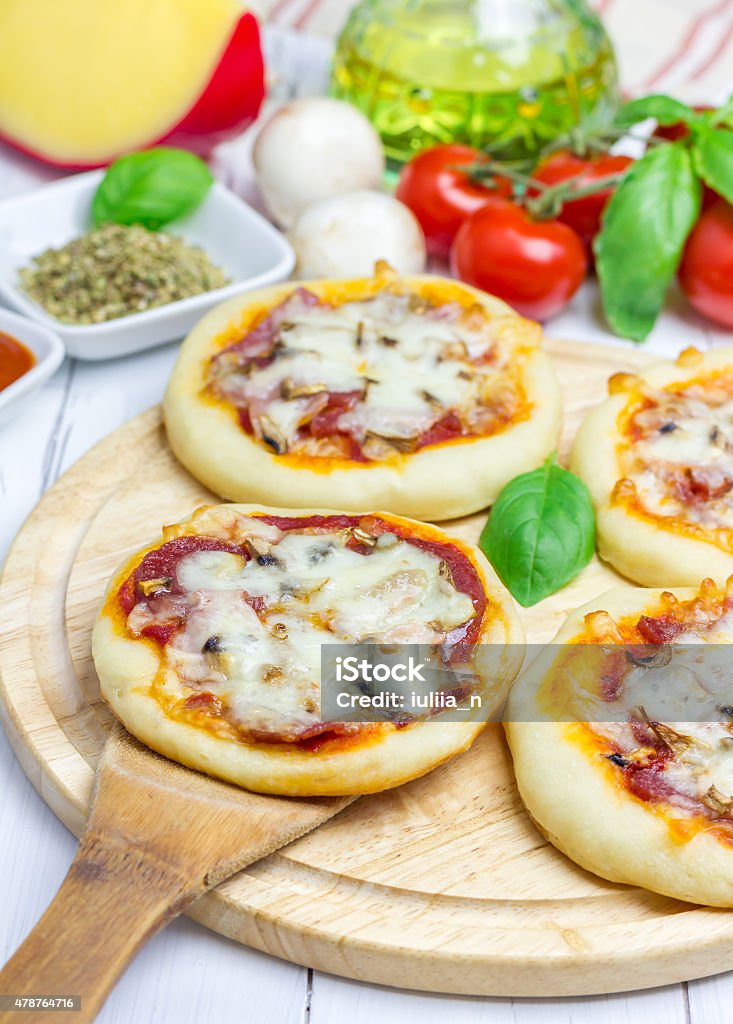Mini pizza with salami, bacon, mushrooms and cheese Mini Pizza Stock Photo
