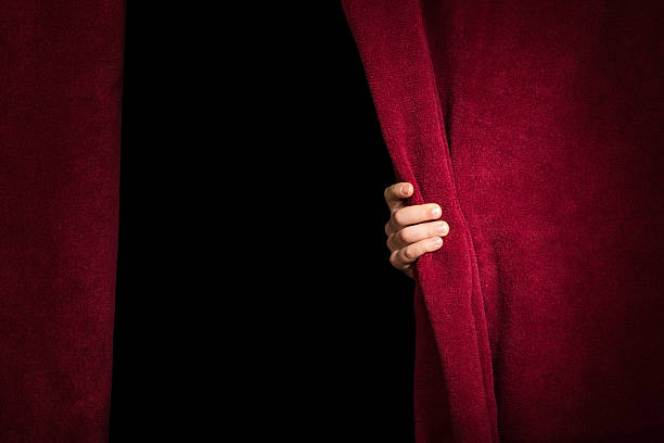 istock Hand appearing beneath the curtain. 478769217