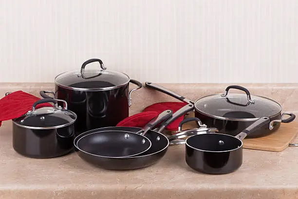 Set of black aluminum cookware on a kitchen counter