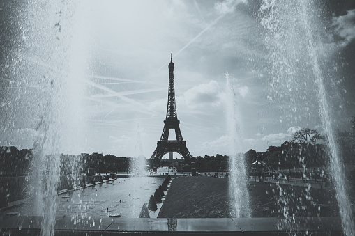 water jets in trocadero fountain on blue sky with  silhouette of eiffel tower