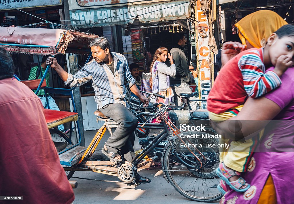 Rickshaw drivers waiting for passengers, India New Delhi, India  - 11, 2014: Cycle rickshaw driver drivers waiting for passengers, people crossing the street . Cycle rickshaws are very popular as a cheap mode of public transportation.  Heat - Temperature Stock Photo