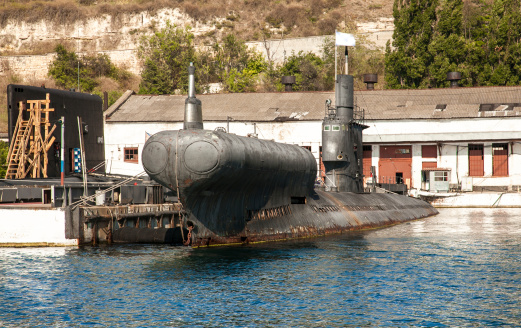 Old black submarine in docks