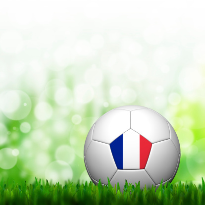 A soccer ball with a France flag on the corner of green soccer field.