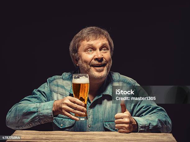 The Smiling Man In Denim Shirt With Glass Of Beer Stock Photo - Download Image Now - 2015, Adult, Adults Only