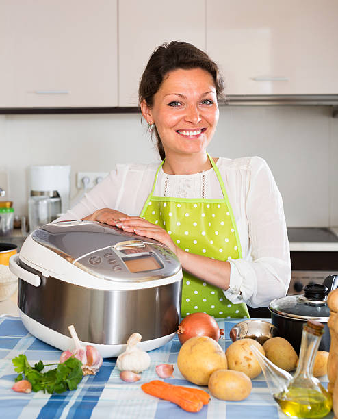 istock Happy  woman using slo-cooker 478776324