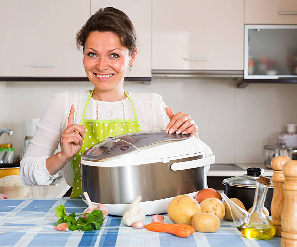 istock Happy  woman using slo-cooker 478776338