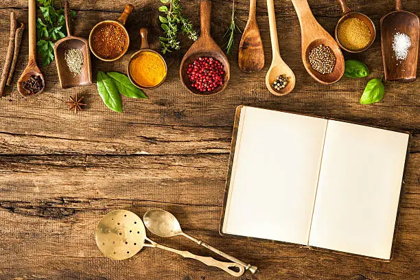 Blank cookbook and spices on wooden table