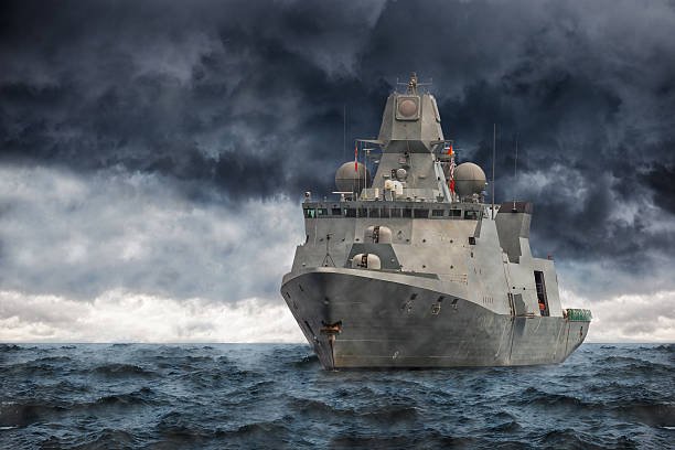 Warship The military ship on sea against heavy clouds. battleship stock pictures, royalty-free photos & images