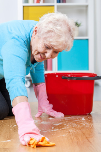Senior woman during washing floor at home