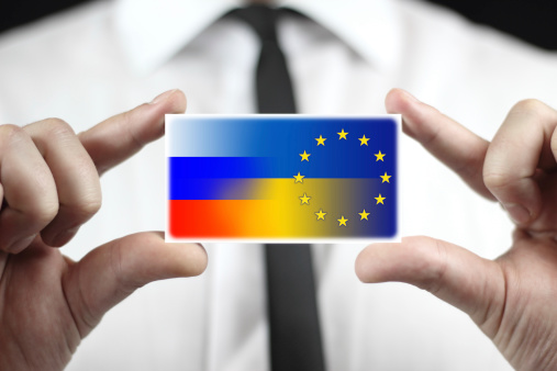 Businessman holding a business card with Ukraine, EU and Russia Flag