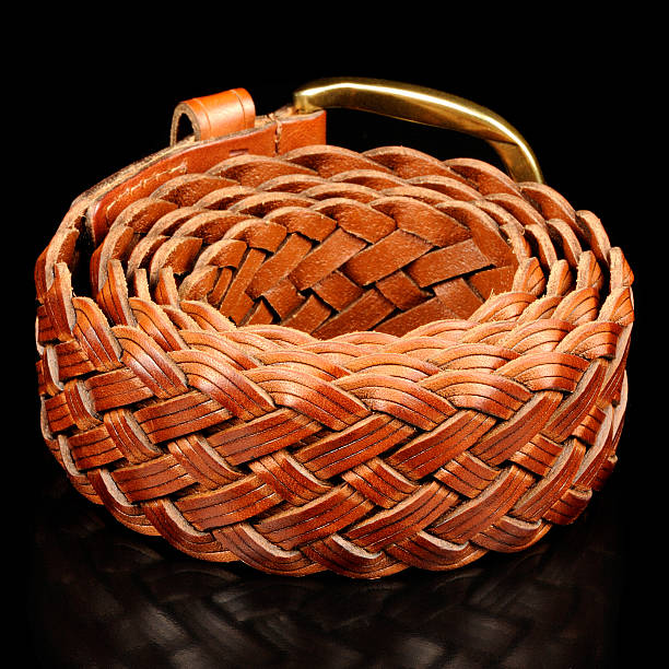 A mens brown braided leather belt on a black background