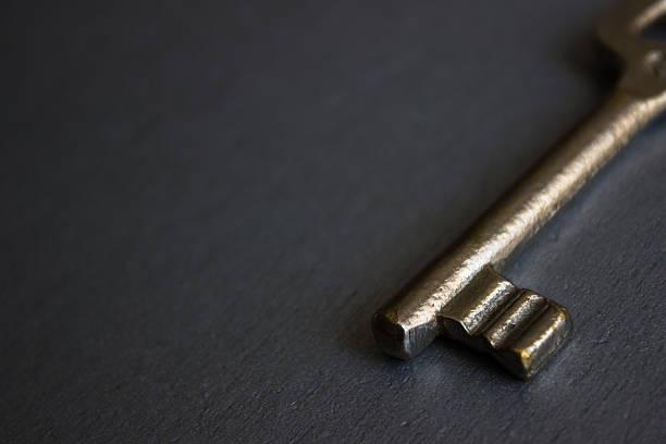 istock High angle view of golden key on a gray background 478782352