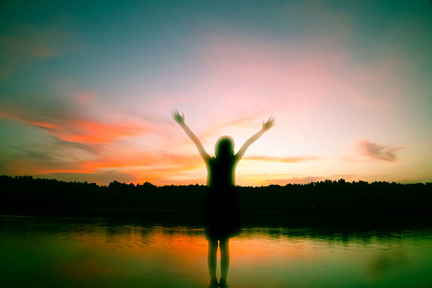 istock girl standing arms out stretched at sunset 478782822